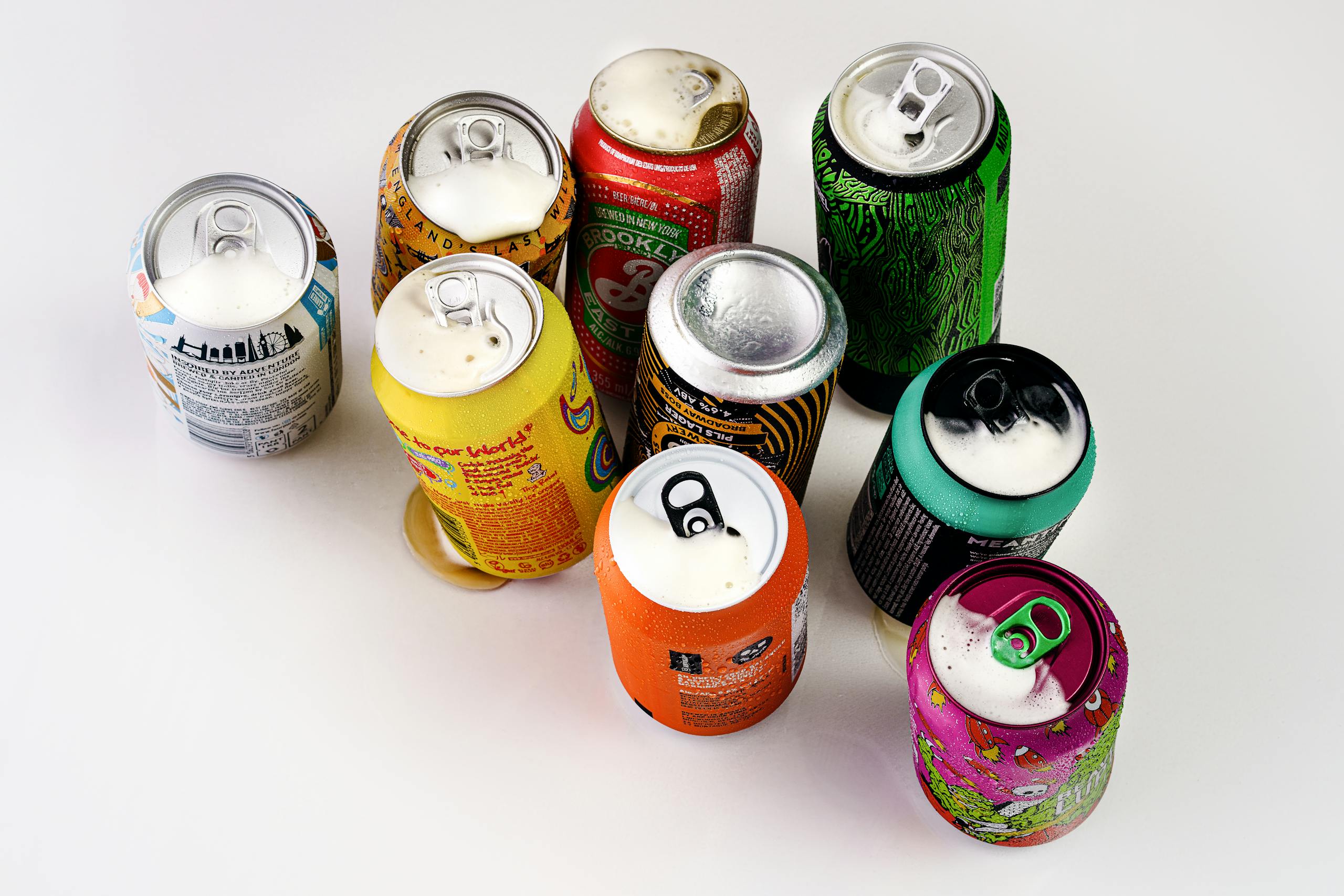 A vibrant display of various open soda cans shot from above in London, England.